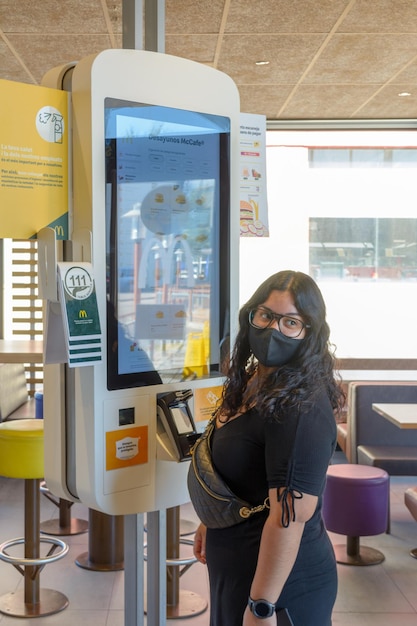 Mallorca spain 07-27-2021young woman placing an order on a touch screen in macdonalds